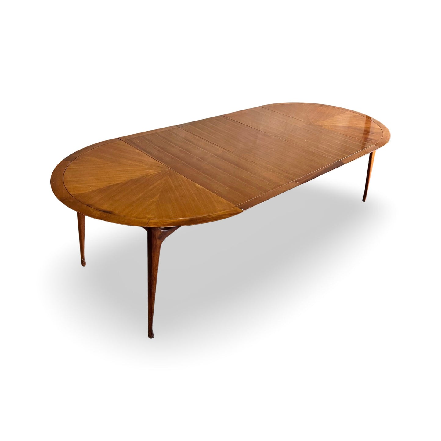 1960s dining table with starburst veneer pattern, extending to 102 inches.