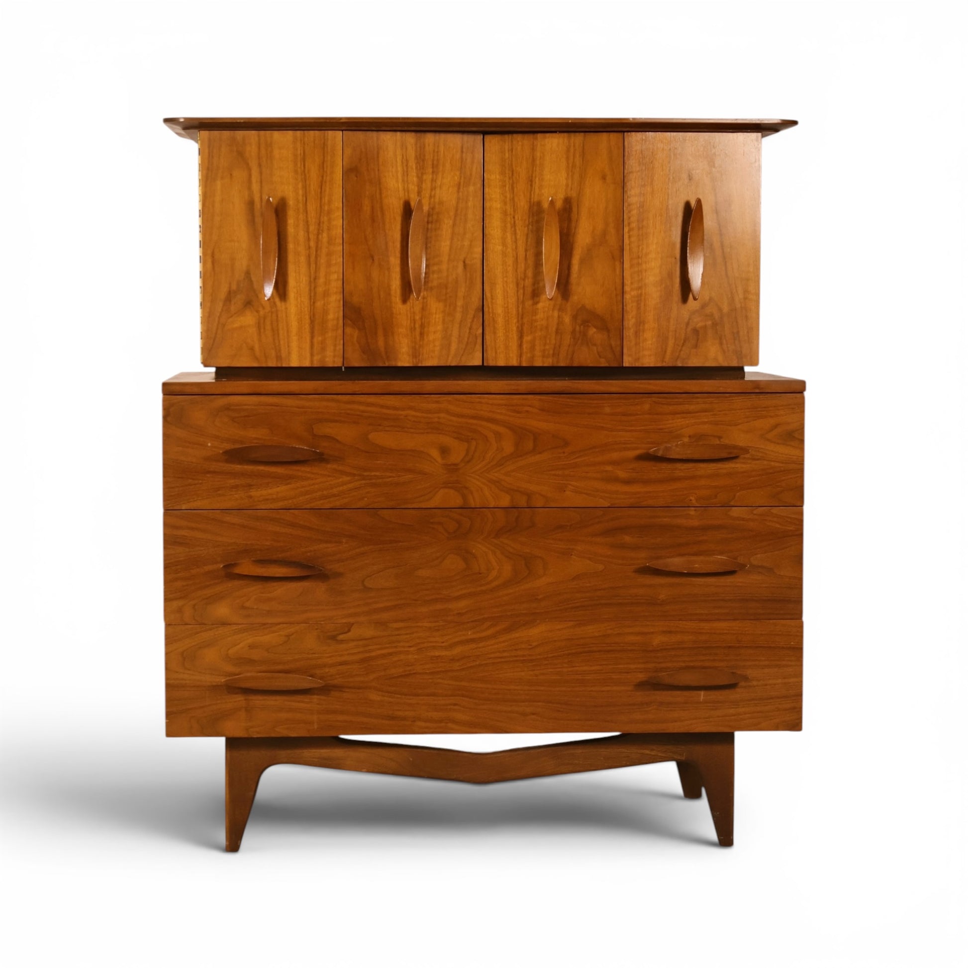 Young Manufacturing sculptural walnut highboy dresser front view with carved bowtie cutout doors and oval drawer pulls