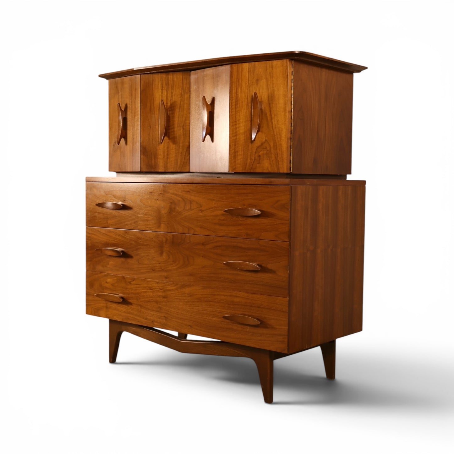 Young Manufacturing sculptural walnut highboy dresser angled view showing bowtie cutout pulls and curved stretcher base
