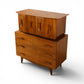 Young Manufacturing sculptural highboy dresser three quarter rear angle showing flared top overhang