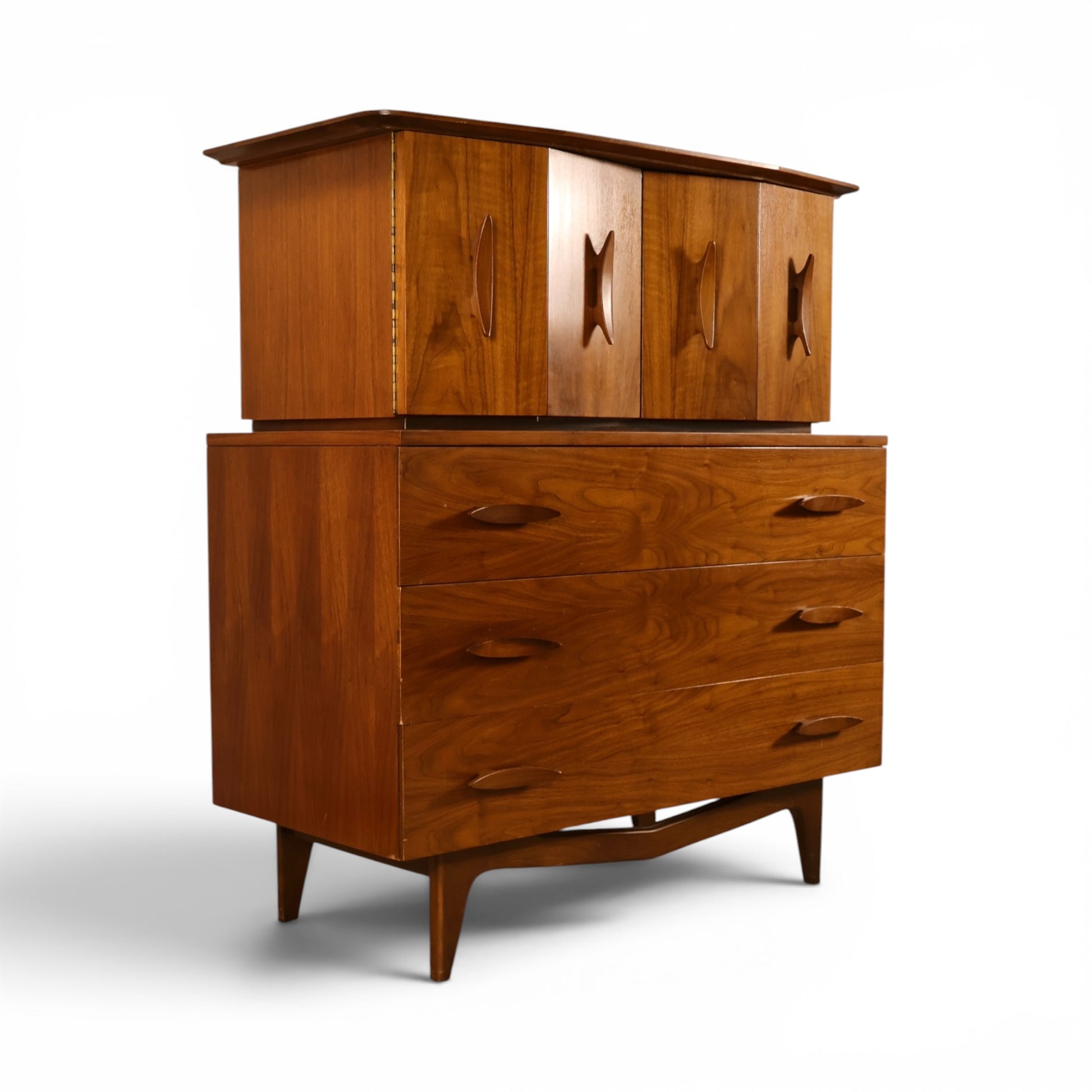 Young Manufacturing sculptural highboy dresser angled view showing carved upper doors and oval pulls