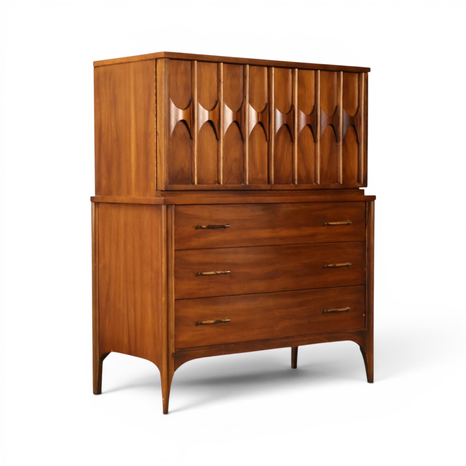 Kent Coffey Perspecta walnut highboy dresser angled view showing sculpted hourglass carvings and arched legs