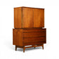 Young Manufacturing concave highboy dresser angled front view showing walnut grain doors and sculpted base