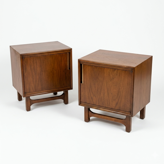 Cavalier Furniture MCM walnut nightstands, matching pair shown side by side with single-door cabinets, recessed bar pulls, and splayed tapered legs with stretcher base, c. 1960s