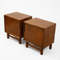 Cavalier Furniture MCM walnut nightstands, matching pair shown from elevated 3/4 angle displaying top surfaces, single-door fronts with brass vertical pulls, and stretcher bases, c. 1960s