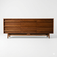 Young Manufacturing MCM walnut lowboy dresser, straight-on front view with all 9 drawers closed showing concave fronts and sculpted arched base, c. 1960s