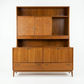 Red Lion MCM walnut two-piece china cabinet, front view with hutch cane panel doors slid open revealing interior shelf, buffet base with four panel doors and two drawers, tapered legs, c. 1960s