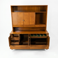 Red Lion MCM walnut two-piece china cabinet, detail view of buffet interior showing small divided compartments with green velvet lining, file storage, and multiple storage trays, cane panel hutch above, c. 1960s