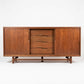 Cavalier Furniture mid-century modern walnut lowboy dresser, straight-on front view showing four center drawers with sculpted pulls, cabinet doors on each side and stretcher base, circa 1960s